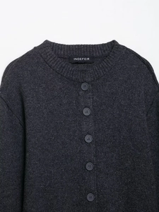 Detailed view of dark grey crew neck cardigan with ribbed knit collar and button front