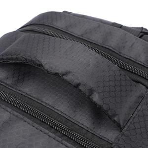 Detailed close-up of a padded honeycomb texture handle and dual zippers on a black backpack