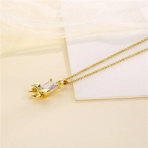 Collana a fiocco in acciaio dorato con zircone rettangolare su tessuto bianco