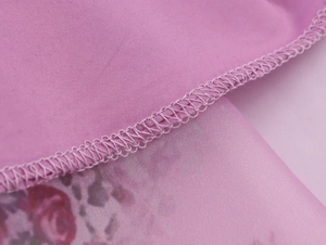 Detailed macro view of high-quality floral organza fabric stitching and pink petal print