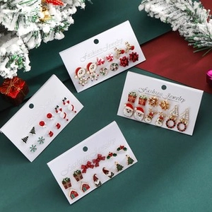 Macro detail of Christmas stud earrings set featuring Santa, reindeer, and tree designs