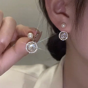 Gold plated hoop earrings with pearls and zircon crystals shown on a model
