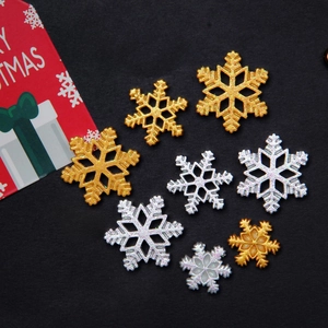 Macro view of gold and silver glitter snowflake charms in various sizes for DIY crafts