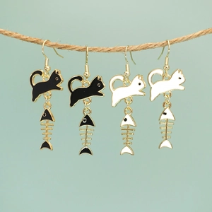 Creative black and white cat and fish bone earrings hanging on a rustic hemp rope
