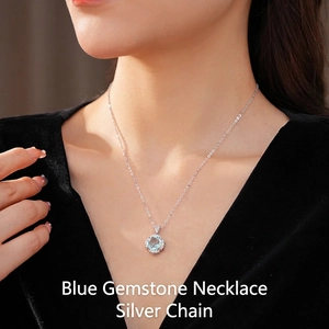 Elegant flower pendant necklace with blue zircon and silver chain on black velvet dress