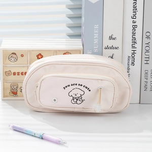 Close-up of a pink multi-layer stationery bag featuring a cute cartoon dog design