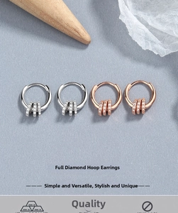 Detail of silver and rose gold S925 earrings with triple diamond-set hanging charms