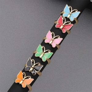 Detail showing colorful enamel butterfly rings on black display poles with gold plating