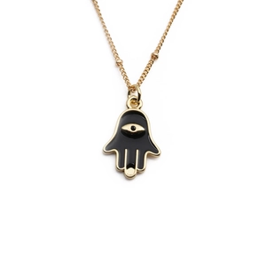 Gold Hamsa Hand necklace with black enamel pendant and evil eye detail on white background