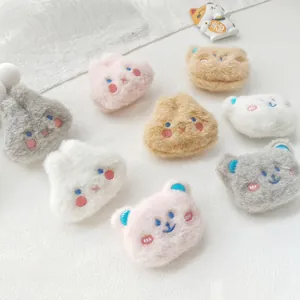 Detail view of plush animal pins featuring soft rabbit and bear faces in pastel colors