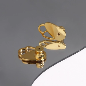 Detailed macro view of gold earring back lifters with a polished reflective finish