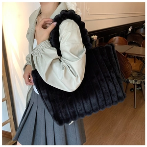 Chic black plush tote bag with ribbed texture and spherical handles for winter style
