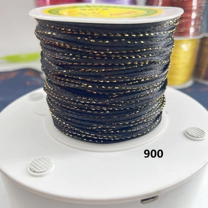 Close-up of black and gold metallic cord spool for handmade jewelry and DIY weaving crafts