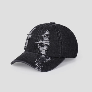 Close-up of distressed black denim baseball cap showing ripped details and vintage texture