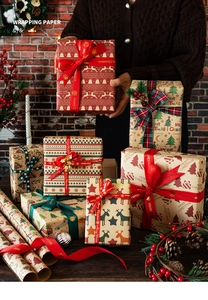 Detail of Christmas wrapping paper rolls with reindeer and tree patterns and festive ribbons