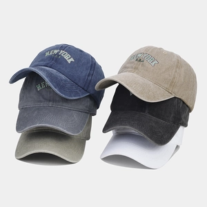 Detailed view of six colors of washed cotton baseball caps with New York embroidery