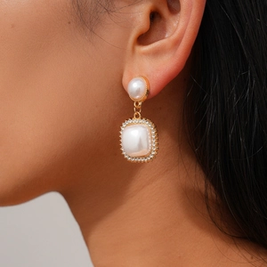 Detailed macro view of vintage gold drop earrings with pearls and crystal accents