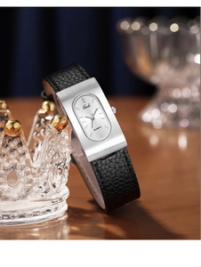 Detail of elegant rectangular silver brushed watch case and black leather strap on a stand