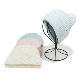 Détail de bonnets en tricot multicolores avec pois pastel et texture en maille côtelée