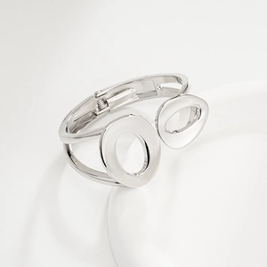 Detail of silver irregular open bangle featuring dual-ring and hollow oval geometric design