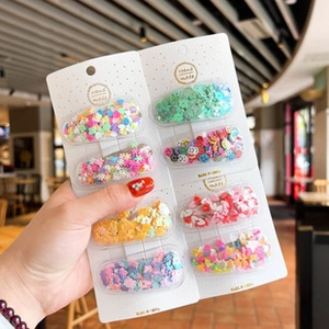 Close-up of eight colorful BB hair clips with cute shapes and heart patterns for girls
