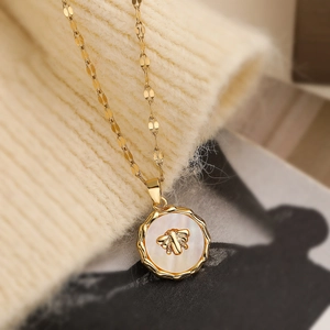 Vintage 18K gold plated bee necklace with mother of pearl pendant on knitted sweater