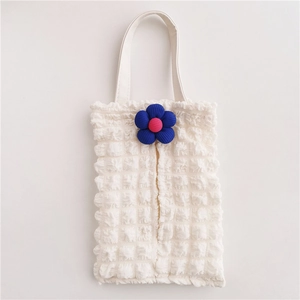 Close-up of white waffle texture car tissue holder with blue knitted flower detail