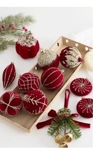 Détail de boules de Noël floquées rouge foncé avec motifs pailletés dorés sur bois