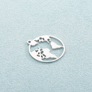 Detailed view of silver stainless steel world map cutout pendant on light blue surface