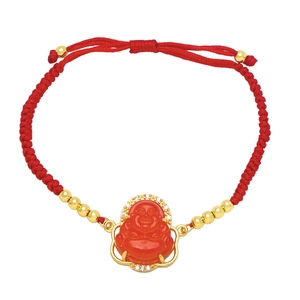 Detail of red string bracelet featuring a gold-framed Buddha pendant with sparkling crystals