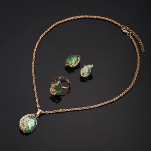 Golden jewelry set featuring teardrop green stones in necklace, earrings, and ring