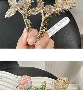 Detailed view of metal rose and rhinestone claw clips in gold finish for elegant hair