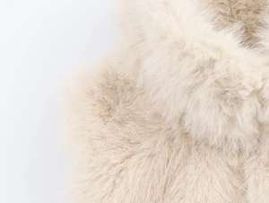 Macro shot of fluffy beige faux fur fabric texture showing soft long plush material