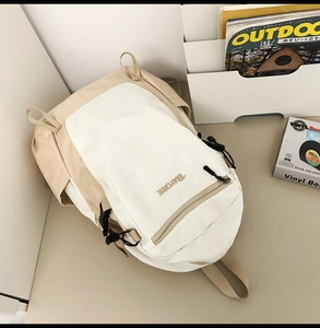 Detail of multi-pocket hiking backpack with cream and khaki patchwork design