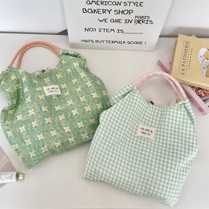 Détail de grands sacs cabas en toile à fleurs et carreaux avec anses en corde