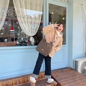Winter outfit featuring a striped plush tote bag and beige faux fur hooded jacket