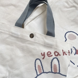 Detail of canvas bag with cute rabbit print, metallic snap button and grey handles