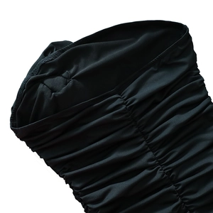 Detail view of the black ruched fabric texture and pleated craftsmanship on the midi dress
