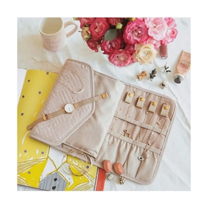 Quilted beige peach skin travel jewelry organizer roll with multiple interior compartments