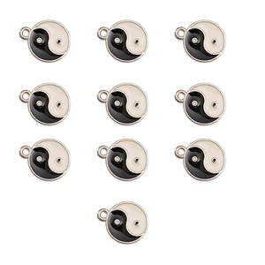 Macro shot of ten round black and white Yin Yang enamel pendants with metal hanging loops