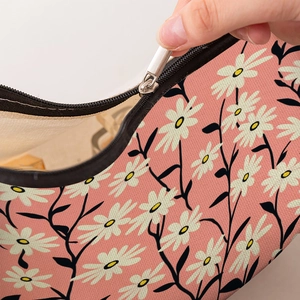 Trousse à maquillage rose avec motif marguerites et fermeture éclair argentée