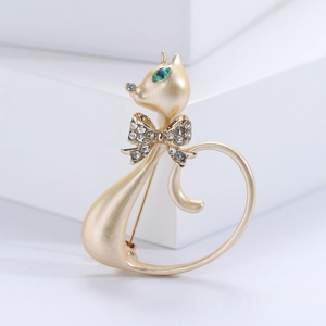 Detailed view of cat-shaped brooch with green rhinestone eyes and sparkling bow tie