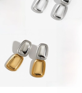 Polished silver and two-tone gold rectangular geometric drop earrings in macro detail