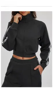 Close-up of black sports tracksuit showing contrasting white stripes and premium fabric texture