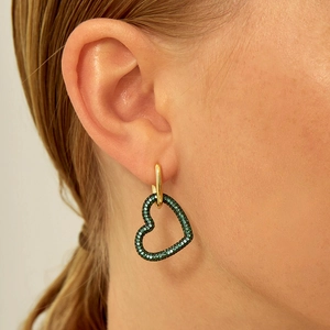 Elegant gold hoop earrings with green heart-shaped crystal charms worn by a model