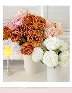 Detailed view of caramel and pink silk roses in a warm home decor setting with lighting