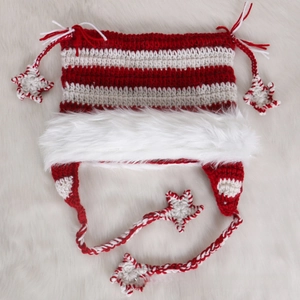 Detailed view of handmade striped knit hat featuring pom-pom stars and faux fur trim