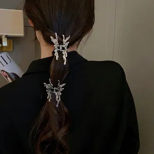Silver liquid metal butterfly hair claw clip with irregular design on dark brown hair