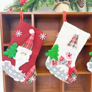 Detail of hanging Santa and Snowman linen stockings with festive Christmas tree decor