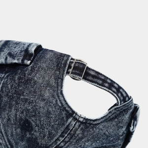 Close-up of the adjustable silver metal buckle and washed denim texture on a brimless hat